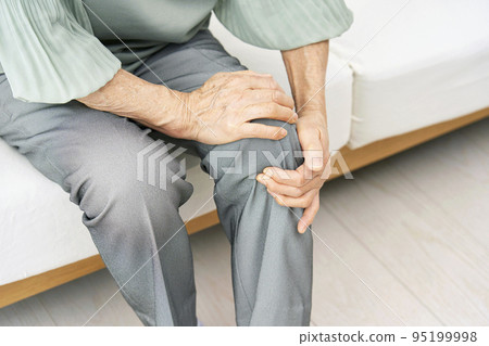 Elderly woman with knee pain in the living room 95199998