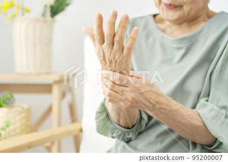 An elderly woman whose hands are numb in the living room 95200007