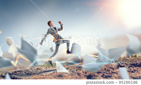 Portrait of energetic businessman jumping in open air 95200186