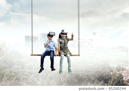 Kids wearing virtual reality goggles 95200244