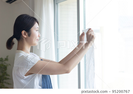 A woman hanging up the laundry 95200767