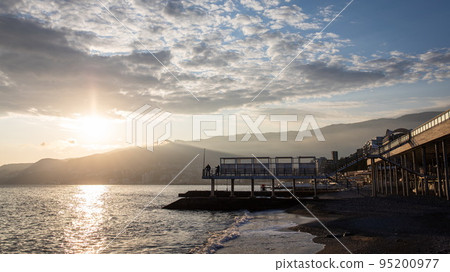 Winter sea, a wave runs over the beach in Yalta. Front view. Winter sea, a wave runs over the beach in Yalta. Front view. 95200977