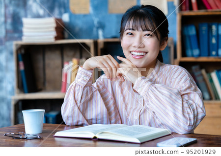 年輕女子在她的房間裡放鬆和閱讀 95201929