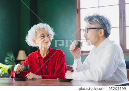 Gray-haired couple drinking espresso Gray-haired couple drinking espresso 95203599