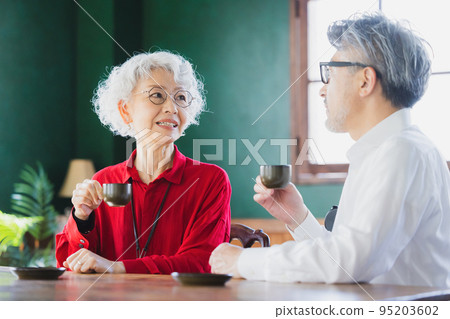 Gray-haired couple drinking espresso 95203602