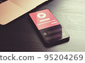 Video Advertising - digital marketing business concept. Targeting programmatic advertising, native social marketing online media ad strategy. Phone lying on wood table with video ad block on screen 95204269