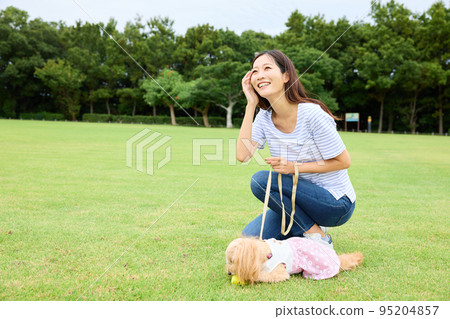 Woman playing with dog in park Woman playing with dog in park 95204857