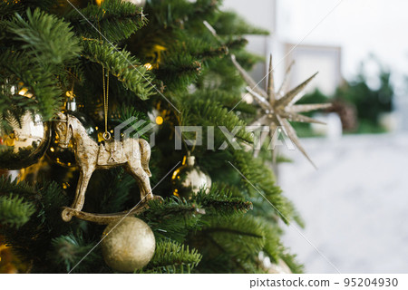 Christmas toy horse and balls hang on the tree, decorated with lights. Copy space Christmas toy horse and balls hang on the tree, decorated with lights. Copy space 95204930