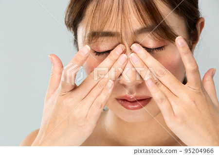 A woman holds her nose. A woman holds her nose. 95204966