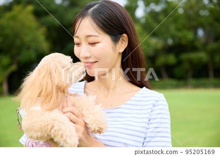 在公園里和狗玩耍的女人 在公園里和狗玩耍的女人 95205169