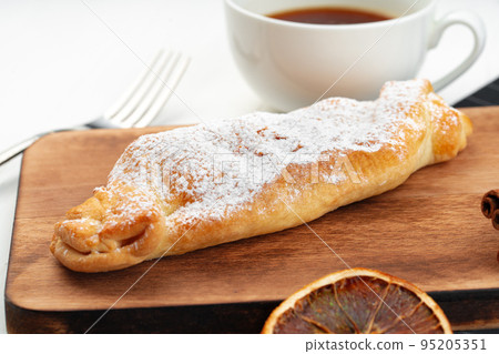 Traditional apple strudel on wooden board, close up Traditional apple strudel on wooden board, close up 95205351
