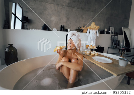 Luxury fashion woman in the morning take breakfast lying in bath Luxury fashion woman in the morning take breakfast lying in bath 95205352