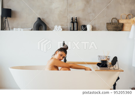 Side view of a woman taking a foam bath at home Side view of a woman taking a foam bath at home 95205360