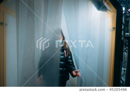 Woman at medic mask is staying in a disinfection tunnel Woman at medic mask is staying in a disinfection tunnel 95205496