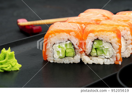 Fresh philadelphia sushi roll served on black plate 95205619