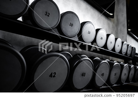 Rows of metal dumbbells on rack for bodybuilding in gym Rows of metal dumbbells on rack for bodybuilding in gym 95205697