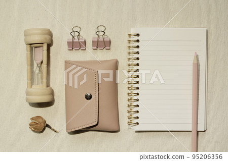 Pink supplies. Sandglass, pouch, clip, notebook, colored pencil on desk. flat lay, top view Pink supplies. Sandglass, pouch, clip, notebook, colored pencil on desk. flat lay, top view 95206356