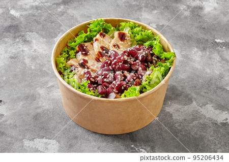 Paper bowl of salad with lettuce, chicken, red beans and mushrooms with teriyaki sauce and sesame Paper bowl of salad with lettuce, chicken, red beans and mushrooms with teriyaki sauce and sesame 95206434