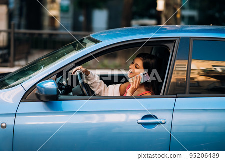 Woman sitting in car and using her smartphone. 95206489