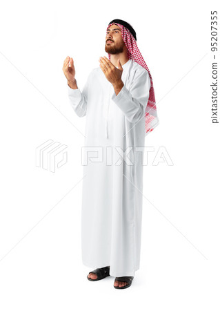 Young Arab man in traditional clothing praying on white background Young Arab man in traditional clothing praying on white background 95207355