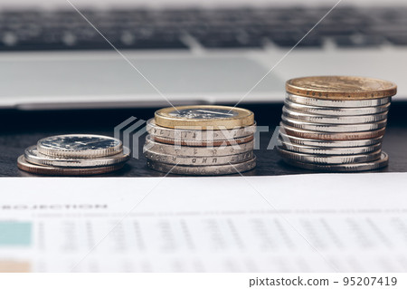 pile of money coins with graph paper on wood table, concept in account, finance and growth of business pile of money coins with graph paper on wood table, concept in account, finance and growth of business 95207419