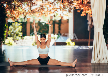 Young woman practicing yoga. Performs an exercise Young woman practicing yoga. Performs an exercise 95208119