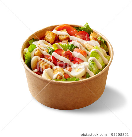 Caesar salad with lettuce, tomatoes, quail eggs, croutons and smoked salmon in cardboard bowl on white 95208861