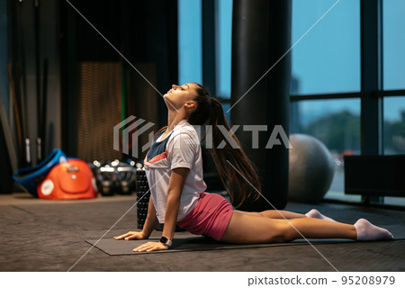 Young woman working out, doing yoga or pilates exercise 95208979