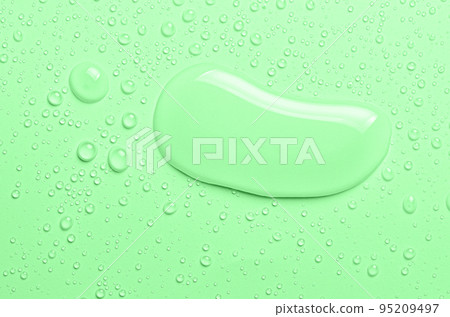 Drops of micellar water or cosmetic tonic on a green background. Close-up, macro photography Drops of micellar water or cosmetic tonic on a green background. Close-up, macro photography 95209497