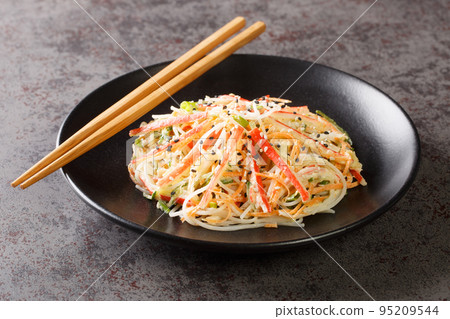 Kani salad made of crab meat and julienne vegetables, all doused in a sweet, spicy, and creamy dressing closeup in the plate. Horizontal Kani salad made of crab meat and julienne vegetables, all doused in a sweet, spicy, and creamy dressing closeup in the plate. Horizontal 95209544