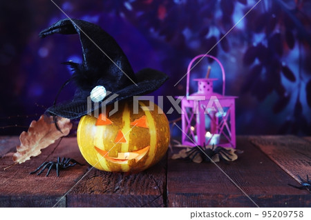 Halloween decorations, pumpkins and a lamp with a burning candle, Halloween celebration, autumn leaves, nature background, evening, festive atmosphere 95209758