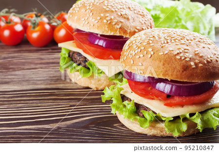 Homemade cheeseburger on brown wooden surface. 95210847