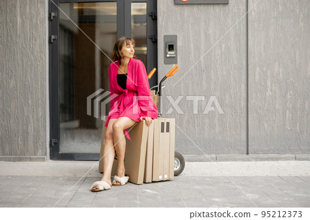 Woman with parcels near residential building 95212373