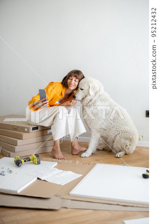 Woman have fun with her cute dog during repairing apartment Woman have fun with her cute dog during repairing apartment 95212432