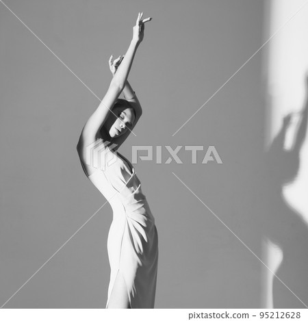 Beautiful woman pose in studio in classic dress Beautiful woman pose in studio in classic dress 95212628