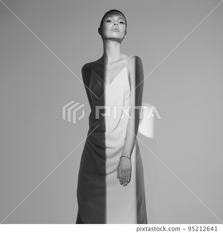 Beautiful woman pose in studio in classic dress 95212641