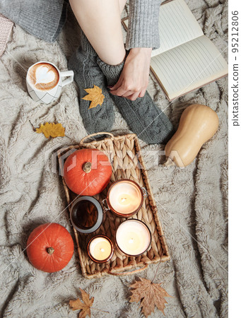 A girl in a sweater and knitted socks sits on a blanket A girl in a sweater and knitted socks sits on a blanket 95212806