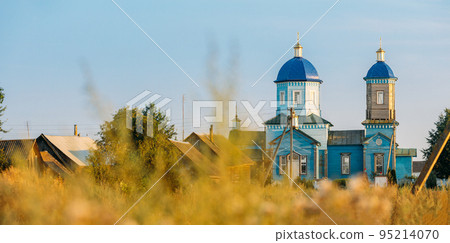 Old wooden orthodox church of the nativity of the Most Holy Theotokos in sunny summer evening. Architectural monument. Glybotskoye, Gomel Region, Belarus 95214070