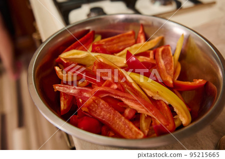 Selective focus on chopped raw sweet and colorful bell peppers on metal bowl. Healthy food. Canning vegetables. Preserving for the winter. Step-by-step conserving harvested crop of organic vegetables Selective focus on chopped raw sweet and colorful bell peppers on metal bowl. Healthy food. Canning vegetables. Preserving for the winter. Step-by-step conserving harvested crop of organic vegetables 95215665
