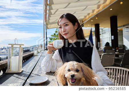 一個女人在狗咖啡館和她的狗共度時光 95216585