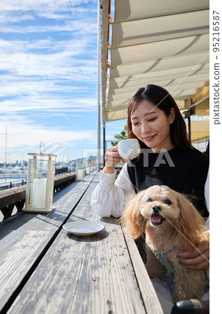 一個女人在狗咖啡館和她的狗共度時光 95216587