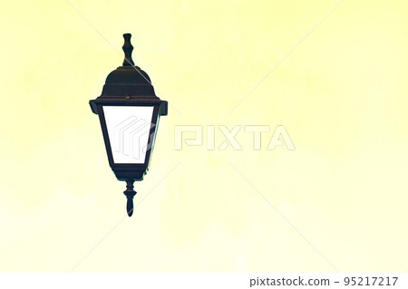 Antique black lantern on a pale yellow background 95217217