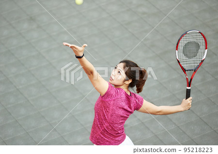 young asian female tennis player serving in match young asian female tennis player serving in match 95218223