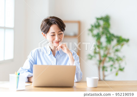 Middle woman teleworking in the living room 95219059