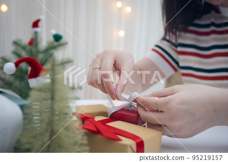 woman hand decorate christmas tree and new year  gift box 95219157