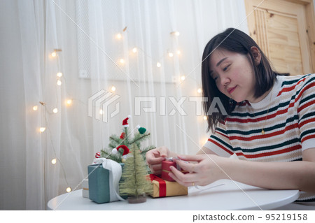 woman hand decorate christmas tree and new year gift box woman hand decorate christmas tree and new year gift box 95219158