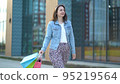 Joyful satisfied woman goes after shopping. A young girl holds bags of different colors in her hands 95219564