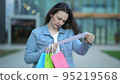 A girl with a cash receipt in her hands on the background of a shopping center after shopping 95219568