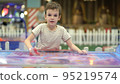 Boy trying to win in the game of air hockey on the playground 95219574
