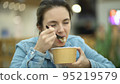 A young girl eats fresh salad from a paper container during her lunch break 95219579